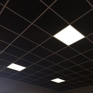 Black polyester fiber acoustic grid ceiling tiles installed in a modern office, reducing noise and improving sound quality. STUDIO ACOUSTICS